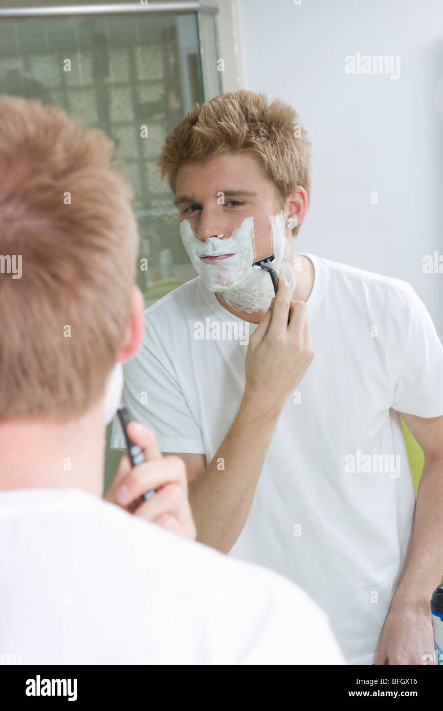 L'uomo la rasatura in specchio Foto Stock