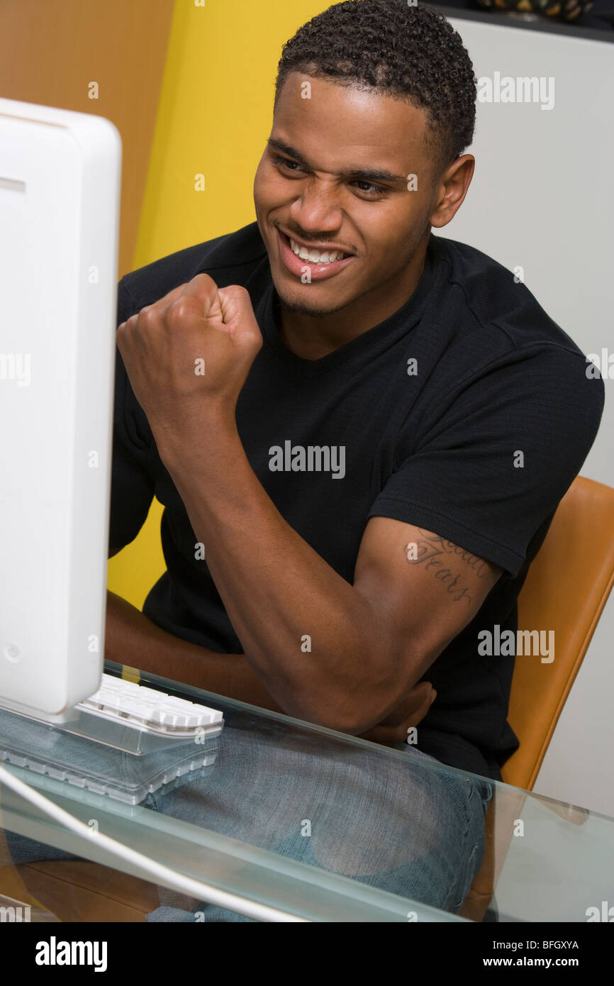 Giovane uomo tramite il computer desktop Foto Stock