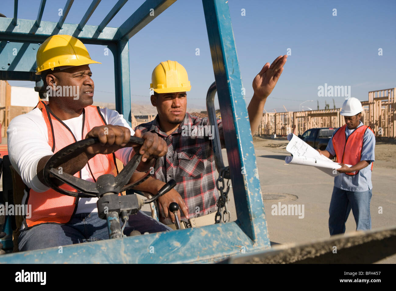 Lavoratore edile che mostrano la direzione di un altro lavoratore veicolo dello sterzo Foto Stock