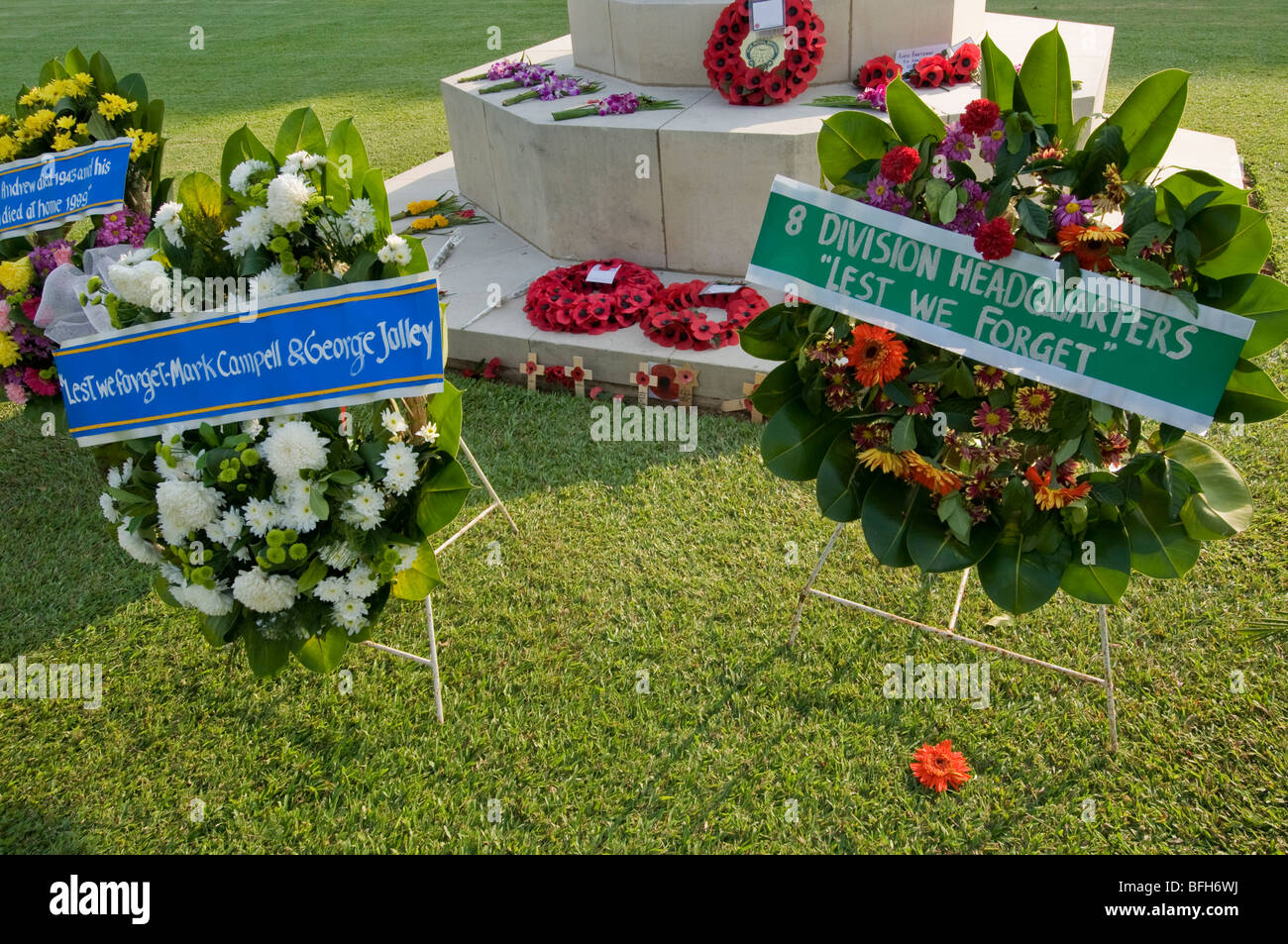 Offerte floreali ai piedi della croce di Kanchanaburi Cimitero di Guerra in Thailandia Foto Stock