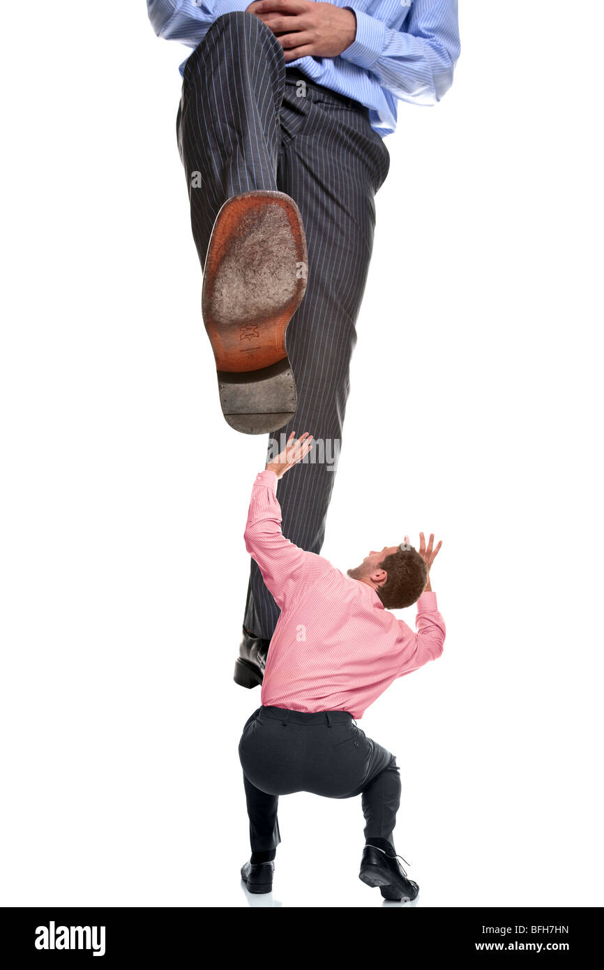 Un imprenditore che sta per essere calpestate da un gigantesco piede, isolato su uno sfondo bianco. Foto Stock