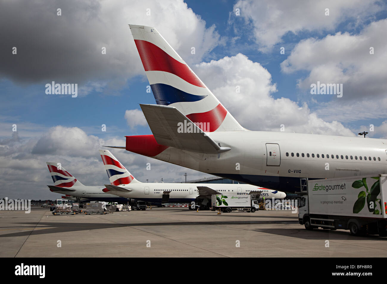 Code di British Airways aeromobile presso il terminale Heathrow aeroporto di Londra Inghilterra REGNO UNITO con Gate Gourmet autocarro frequentando Foto Stock