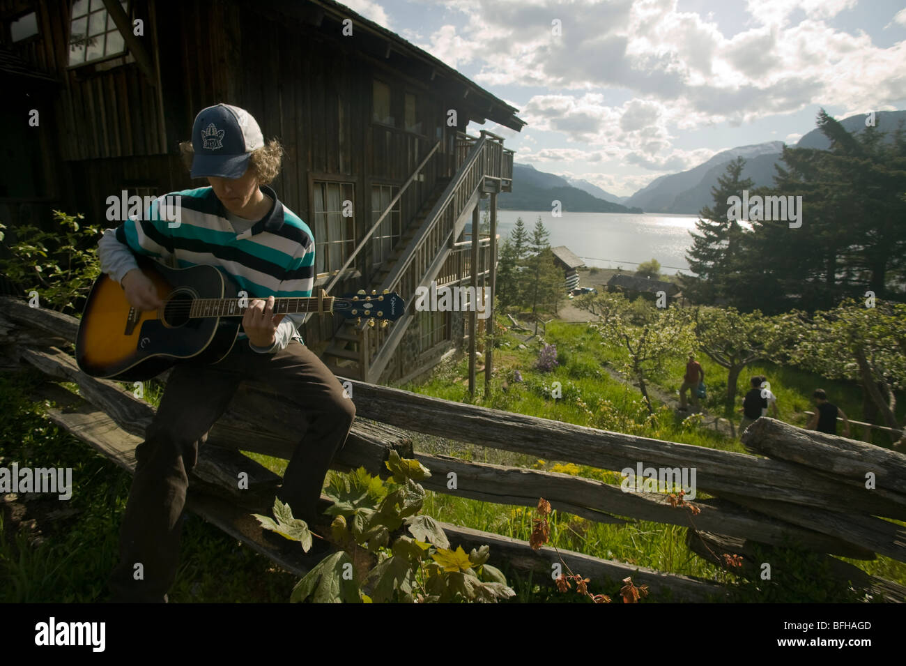 Un giovane uomo svolge la sua chitarra al ben noto Strathcona Park Lodge, British Columbia, Canada. Foto Stock