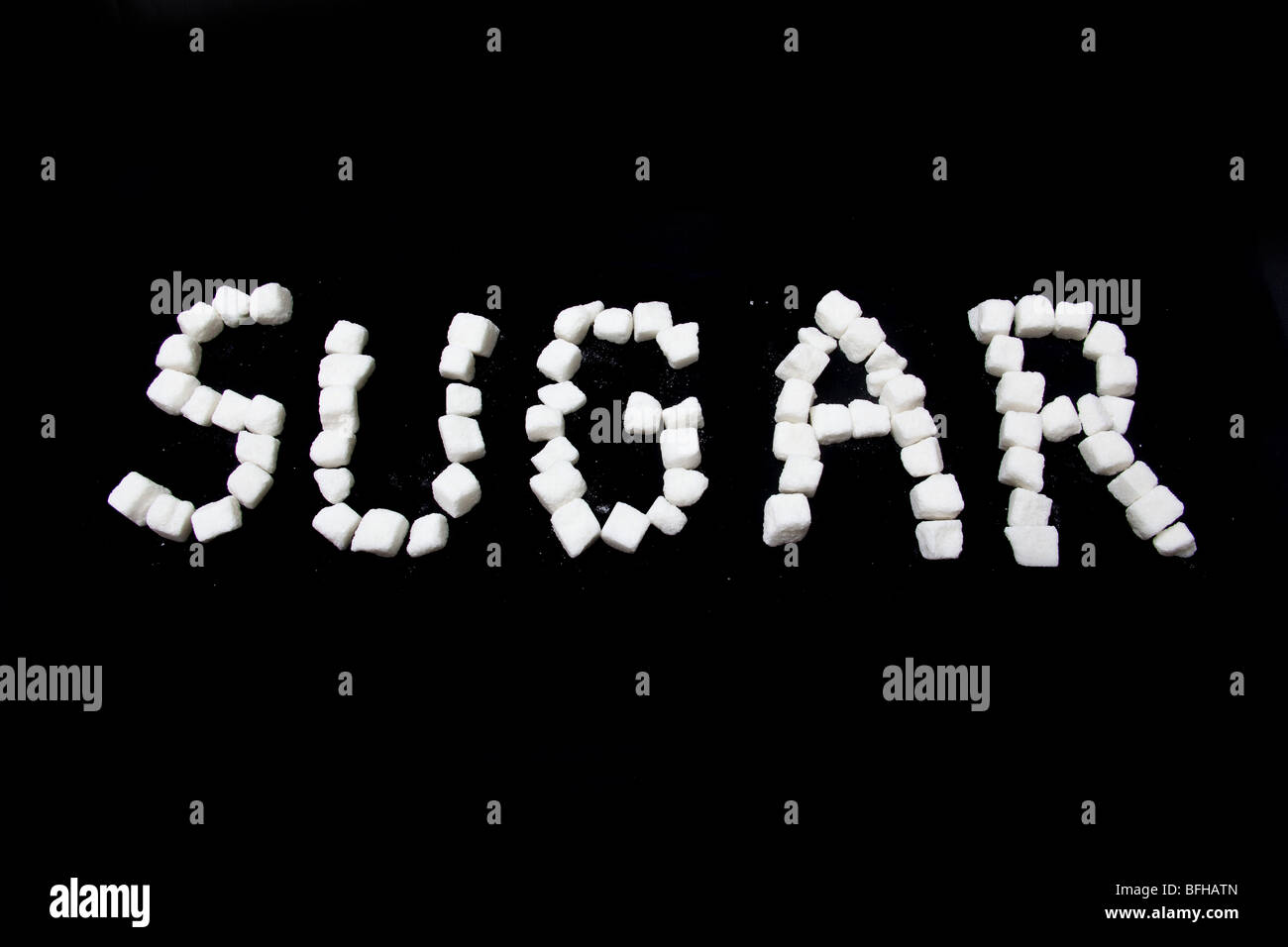 Scritto dello zucchero in zollette di zucchero su un nero di sfondo per studio. Foto Stock