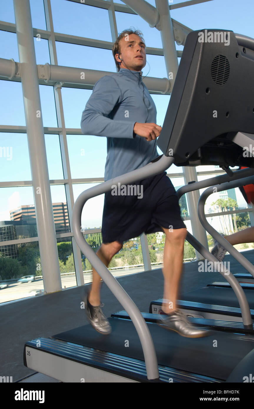 Uomo di jogging sul tapis roulant in palestra Foto Stock