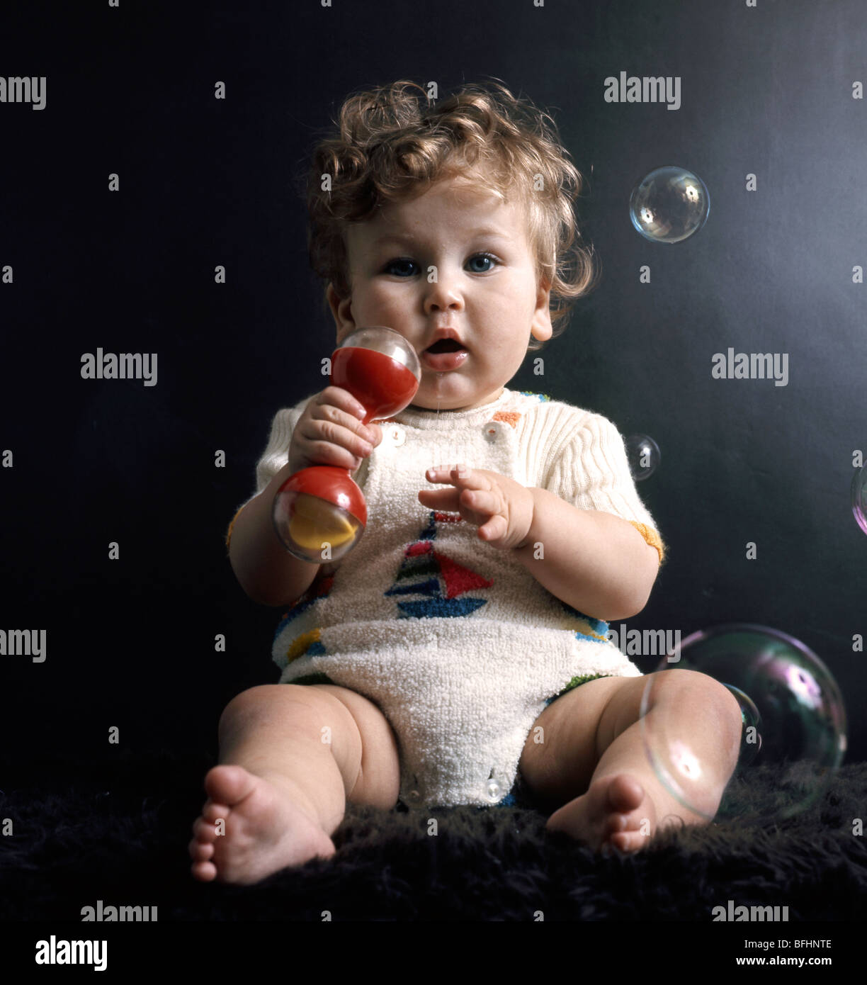 Sei mesi baby affascinato con bolle di sapone Foto Stock