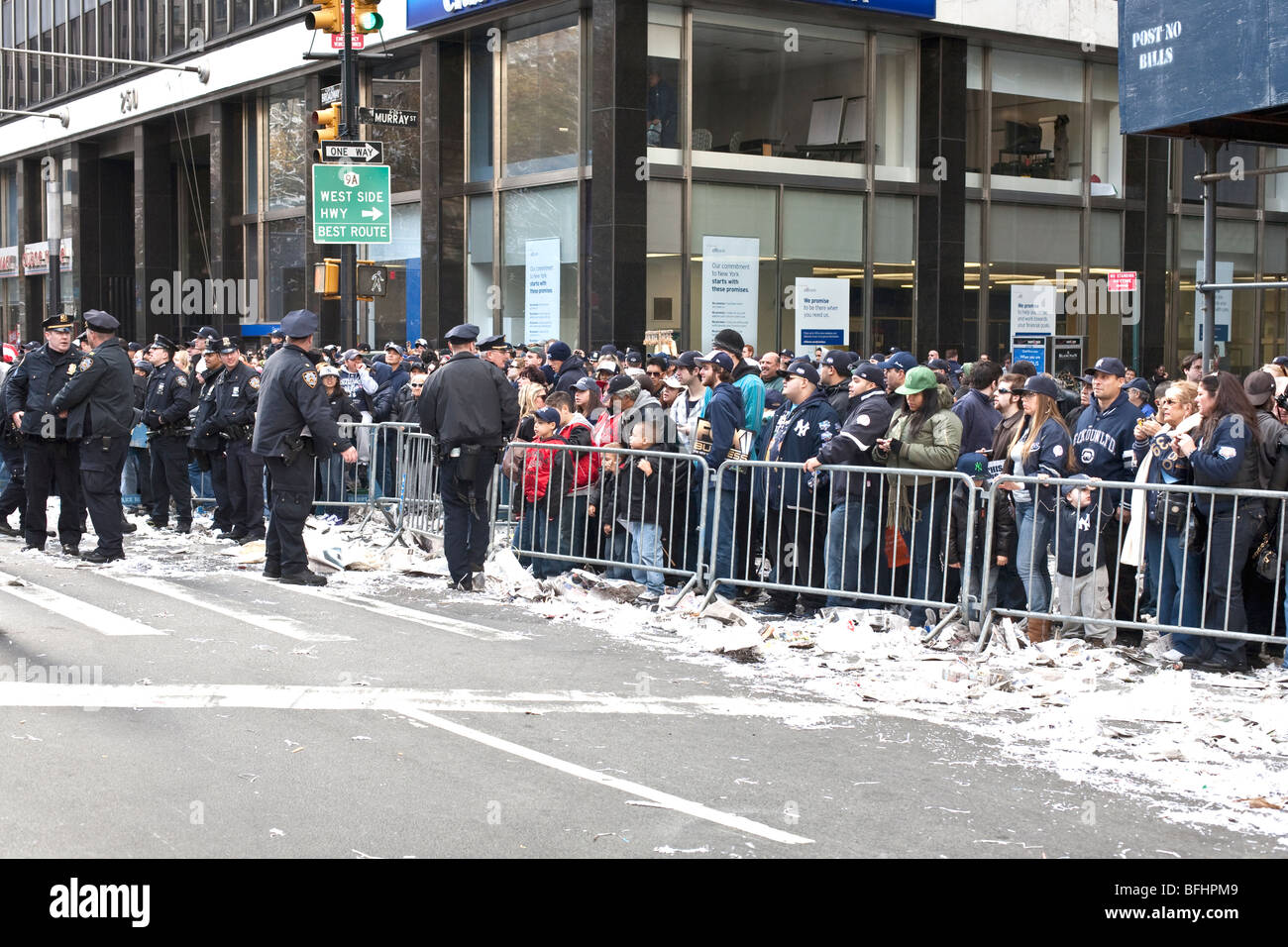 New York folla dietro barriere Lower Broadway a guardare un monitor video live di City Hall cerimonia dopo Yankees World Series vincere Foto Stock