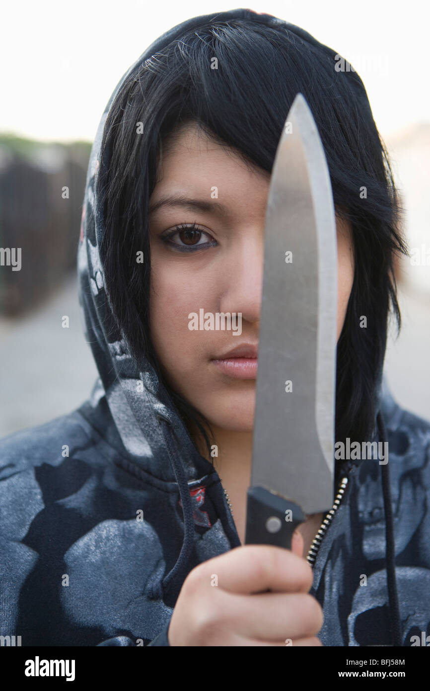 Giovane donna in posa con il coltello Foto Stock