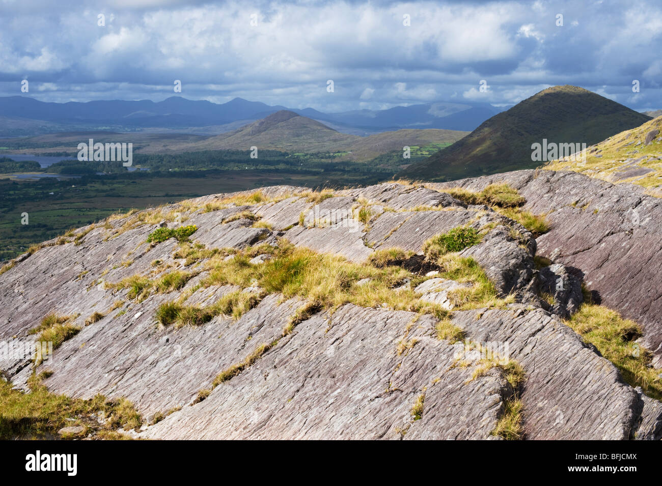 Vecchio rosso roccia arenaria affacciato sulla Baia di Kenmare dalla sommità del Healy Pass, Beara, nella contea di Kerry, Irlanda Foto Stock