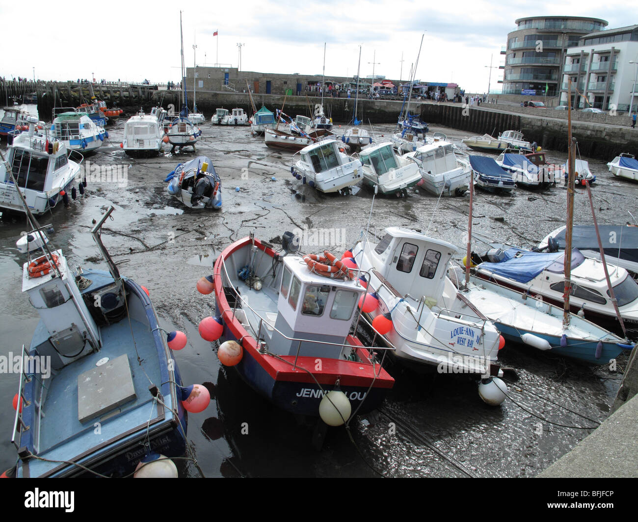 Piccole barche nel porto di West Bay, Dorset a bassa marea in estate Foto Stock