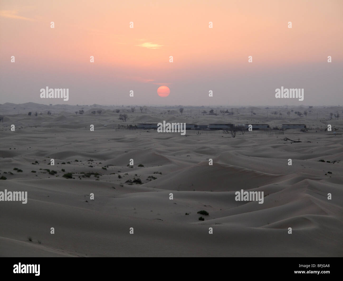 Sun impostazione oltre le dune di sabbia del deserto al di fuori citta' di Abu Dhabi nel mese di novembre, EMIRATI ARABI UNITI Foto Stock