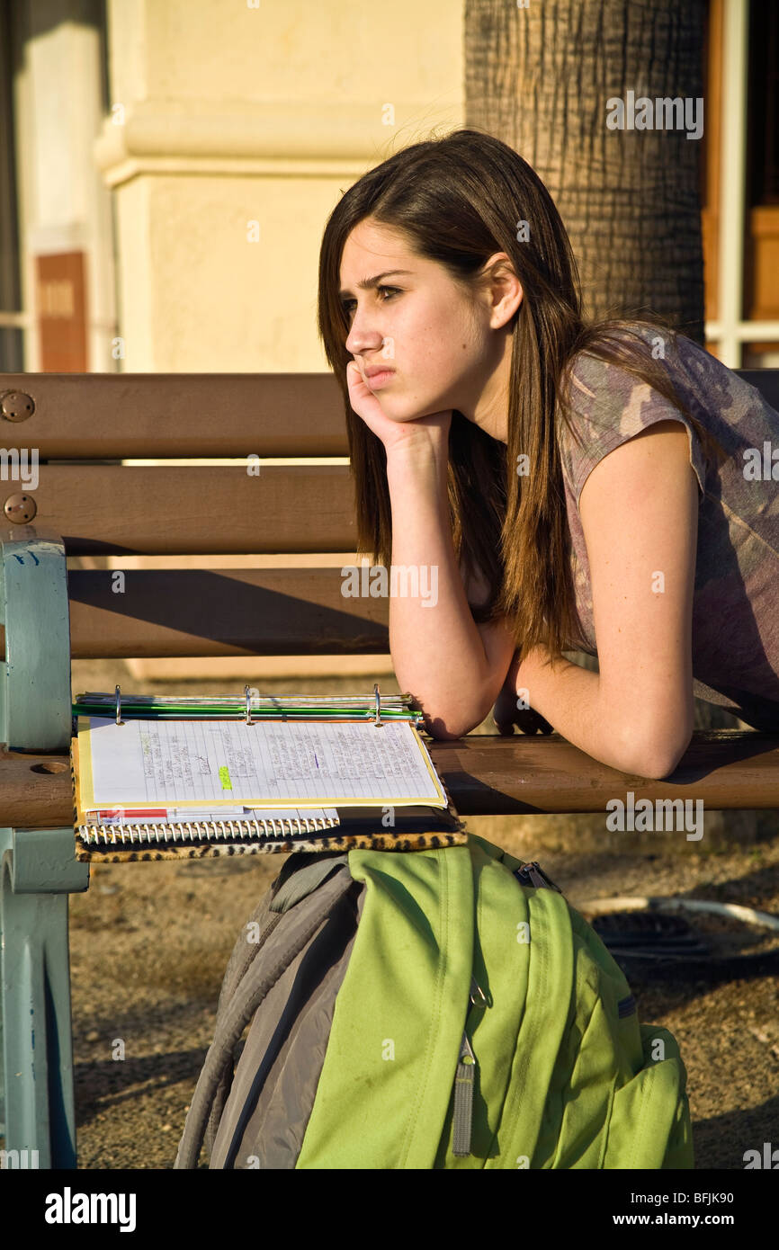 Teen ragazza 12-14 anni pensiero riflettente meditando compiti sul banco di prova all'esterno. California signor © Myrleen Pearson Foto Stock