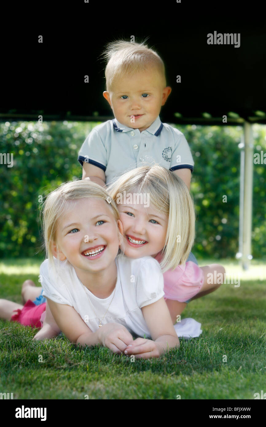 Tre bambini che giocano in giardino, Svezia. Foto Stock