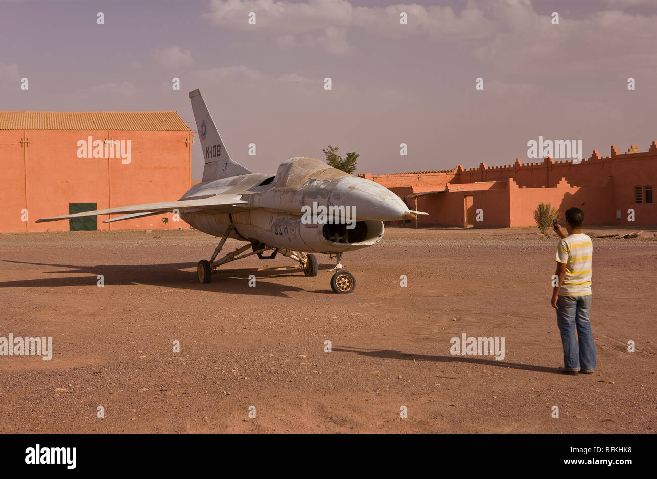 OUARZAZATE, Marocco - Tourist prende la foto del jet fighter prop sul set del film di Atlas Corporation Studios. Foto Stock
