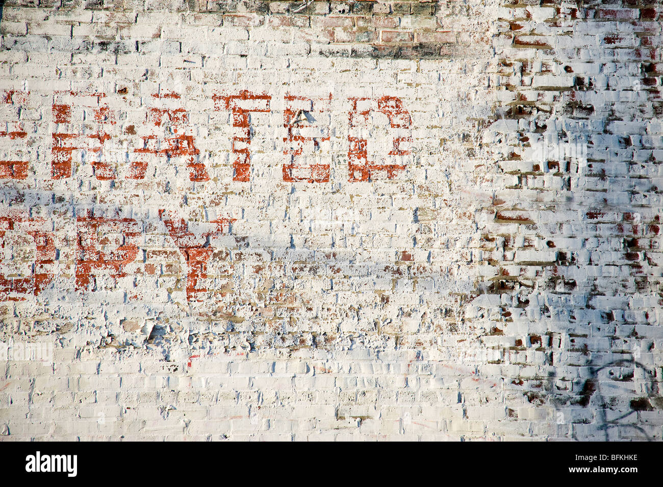 Peeling segno di vernice muro di mattoni in vicolo, scarsa sezione di Philadelphia, Stati Uniti d'America Foto Stock