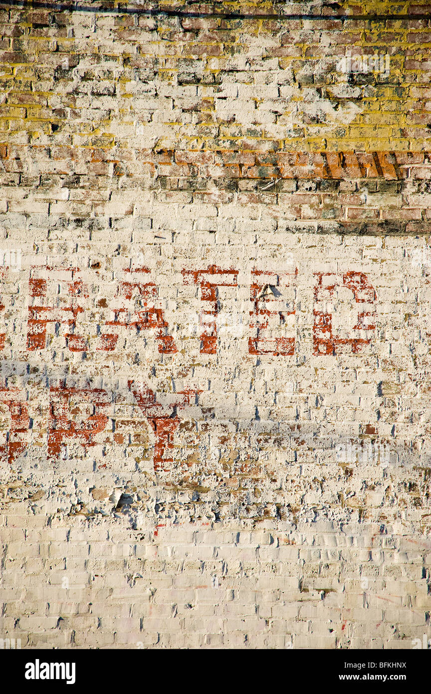 Peeling segno di vernice muro di mattoni in vicolo, scarsa sezione di Philadelphia, Stati Uniti d'America Foto Stock