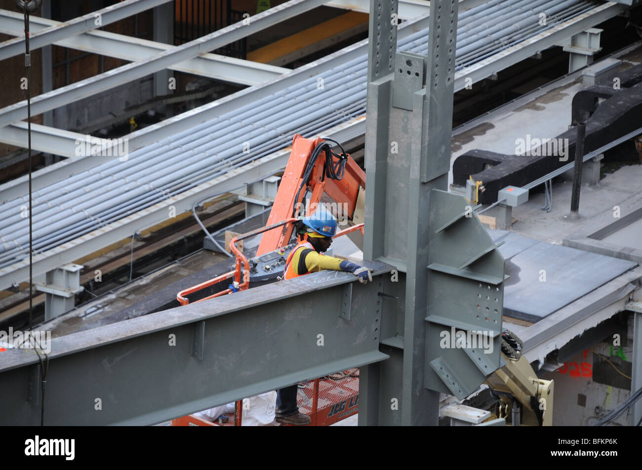 Un lavoratore che guida una trave in acciaio in luogo presso il World Trade Centre in un cantiere in Lower Manhattan. Foto Stock