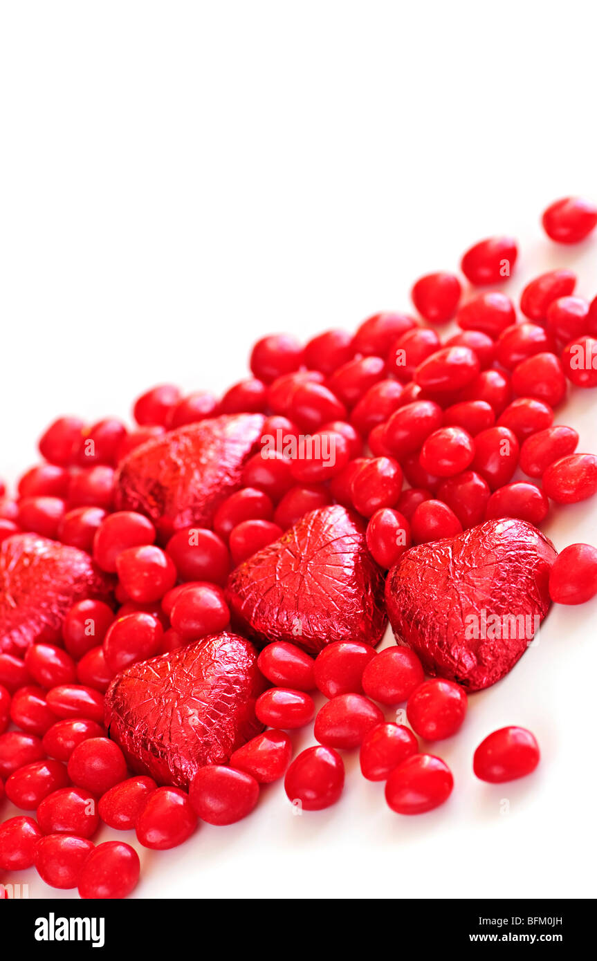 Rosso di San Valentino di caramelle e la lamina di cioccolatini incartati su sfondo bianco Foto Stock