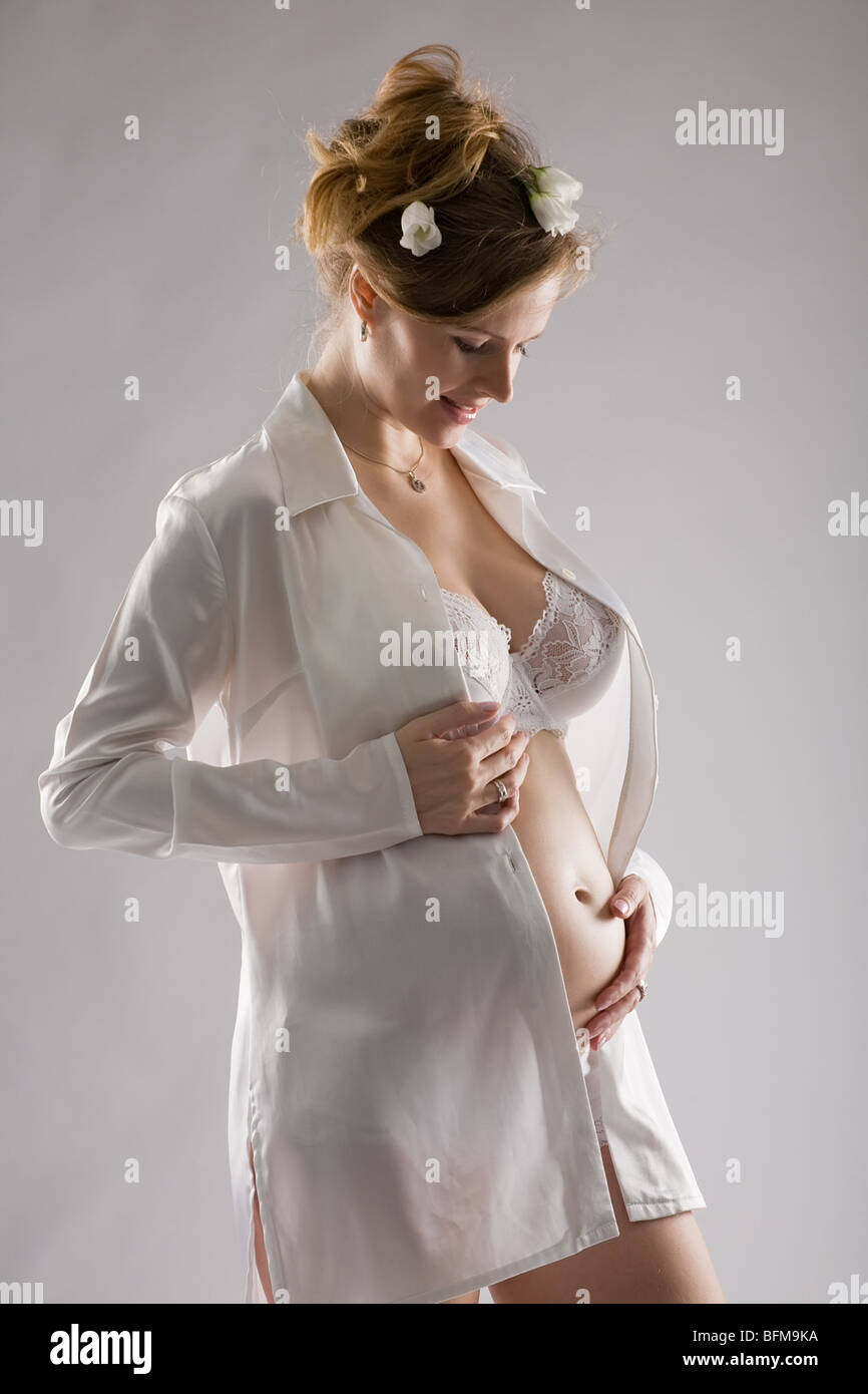 Fine-art il ritratto di una donna in stato di gravidanza su sfondo grigio Foto Stock