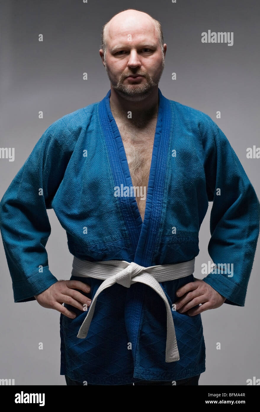 Uomo in blu scuro kimono tiene le mani sui fianchi Foto Stock