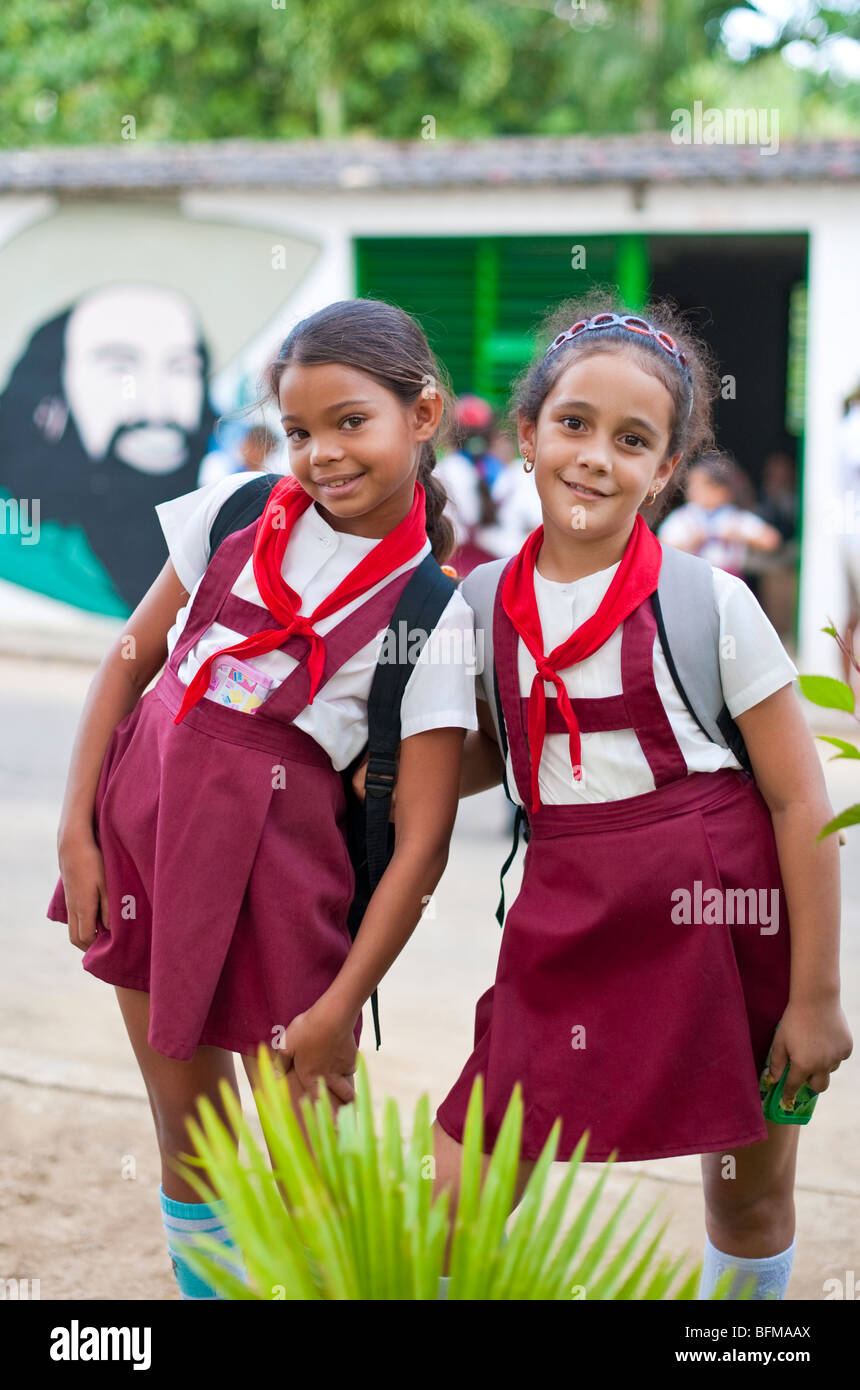 2 giovani allievi pone in corrispondenza delle loro zone rurali scuola cubana di fronte a Cienfuegos pittura murale Foto Stock