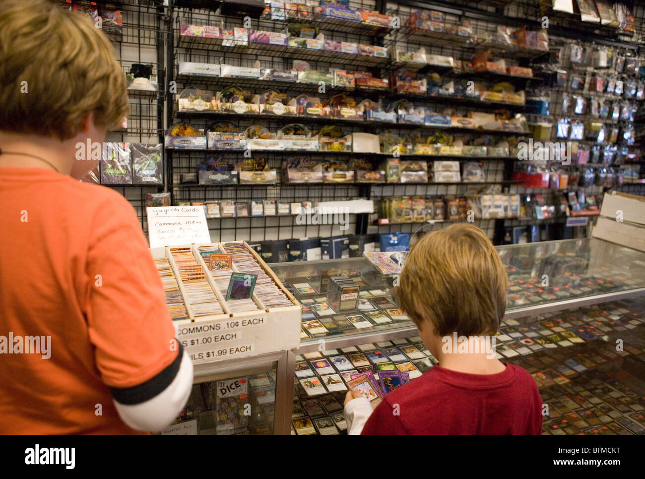 Due ragazzi guardando le carte commercio in un comic book shop, Stati Uniti Foto Stock