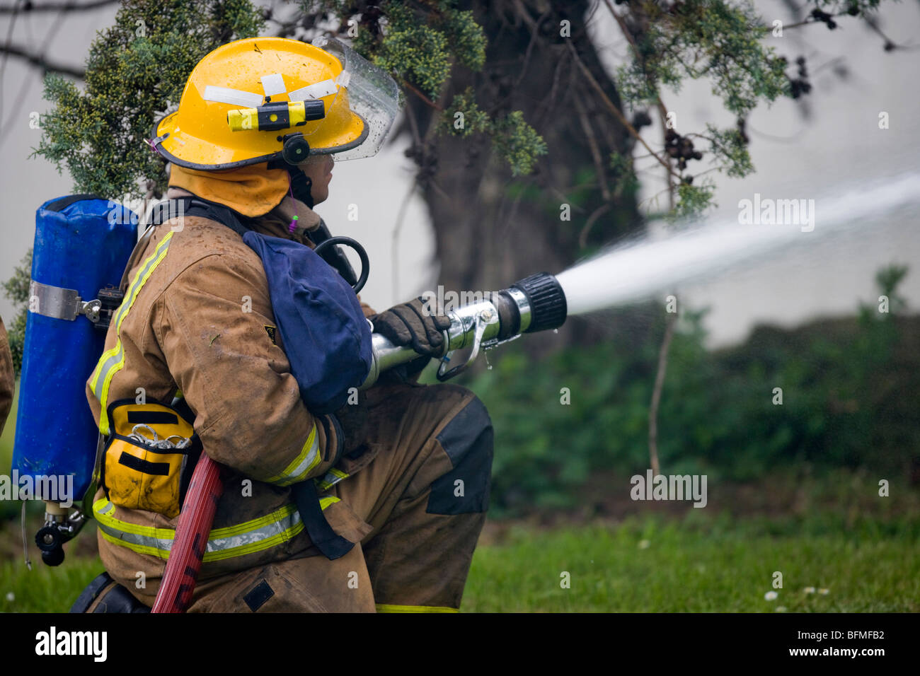 Fire fighter di combattere il fuoco con il tubo flessibile, Martedì, Novembre 17, 2009. Foto Stock