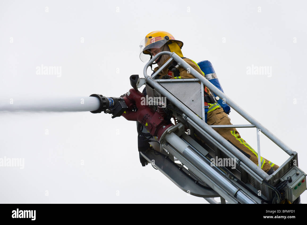 Fire fighter di combattere il fuoco con il tubo flessibile dalla scaletta della piattaforma, Martedì, Novembre 17, 2009. Foto Stock