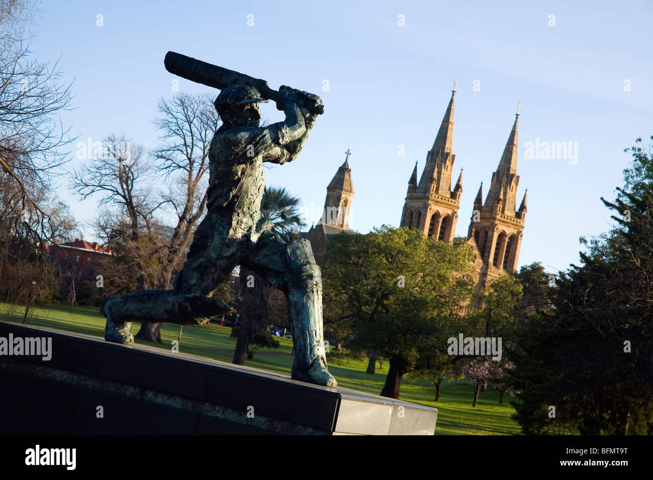 In Australia, in Sud Australia, Adelaide.Statua del Don (Sir Donald Bradman) con la Cattedrale di San Pietro sullo sfondo. Foto Stock