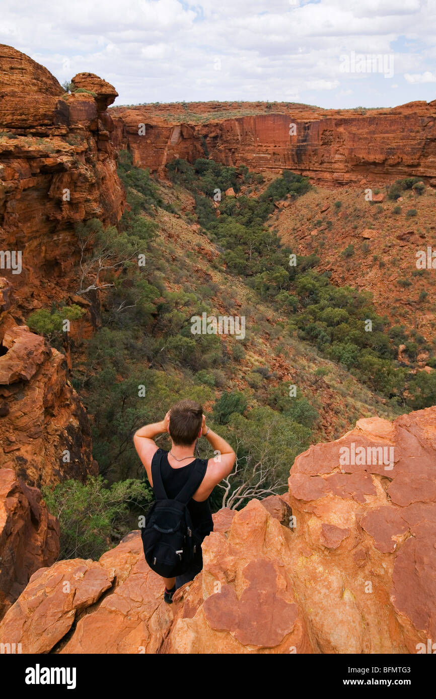 Australia, Territorio del Nord, Watarrka (Kings Canyon) Parco Nazionale. Un uomo si affaccia su Kings Canyon. (MR) (PR) Foto Stock