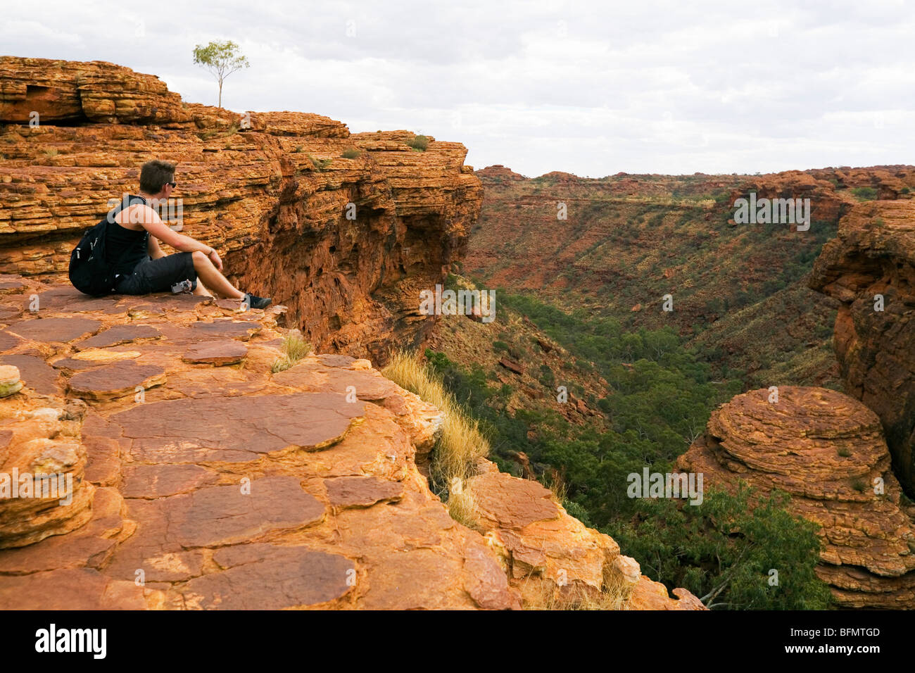 Australia, Territorio del Nord, Watarrka (Kings Canyon) Parco Nazionale. Un escursionista si affaccia su Kings Canyon. (MR) (PR) Foto Stock