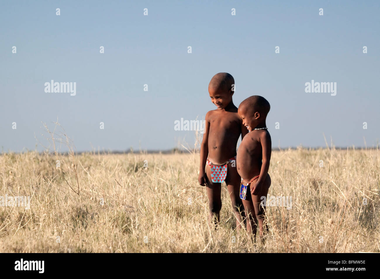 Il Botswana, Makgadikgadi. I Boscimani i bambini in piedi le erbe secche del Kalahari Foto Stock