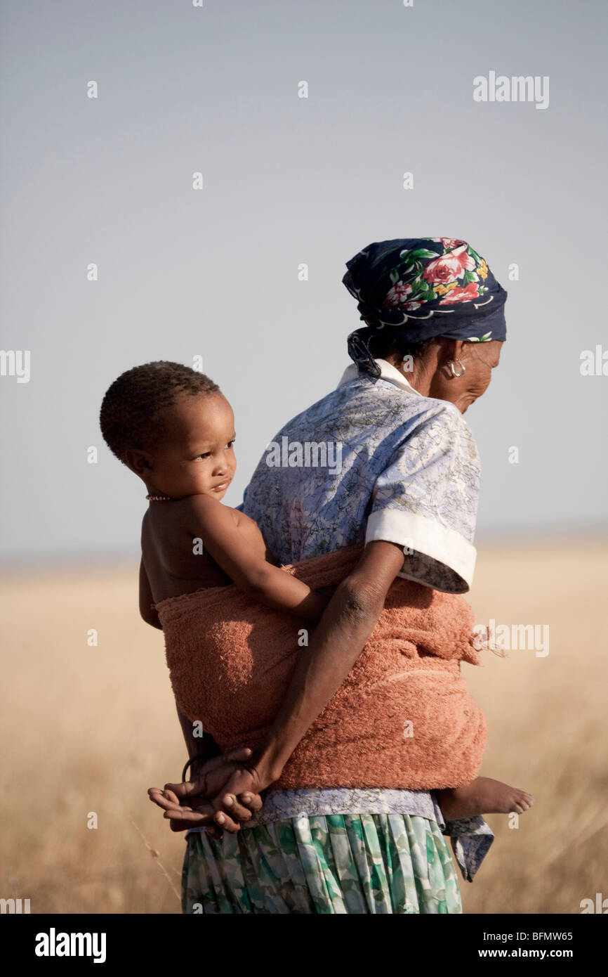 Il Botswana, Makgadikgadi, boscimane di madre porta il suo bambino Foto Stock