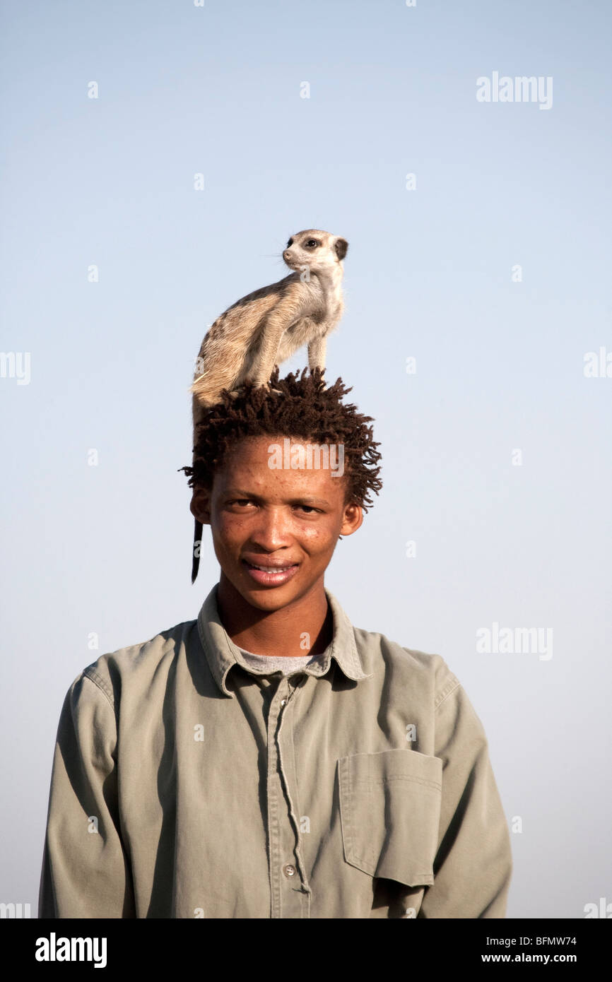 Il Botswana, Makgadikgadi, boscimane con un meerkat sulla sua testa. Foto Stock