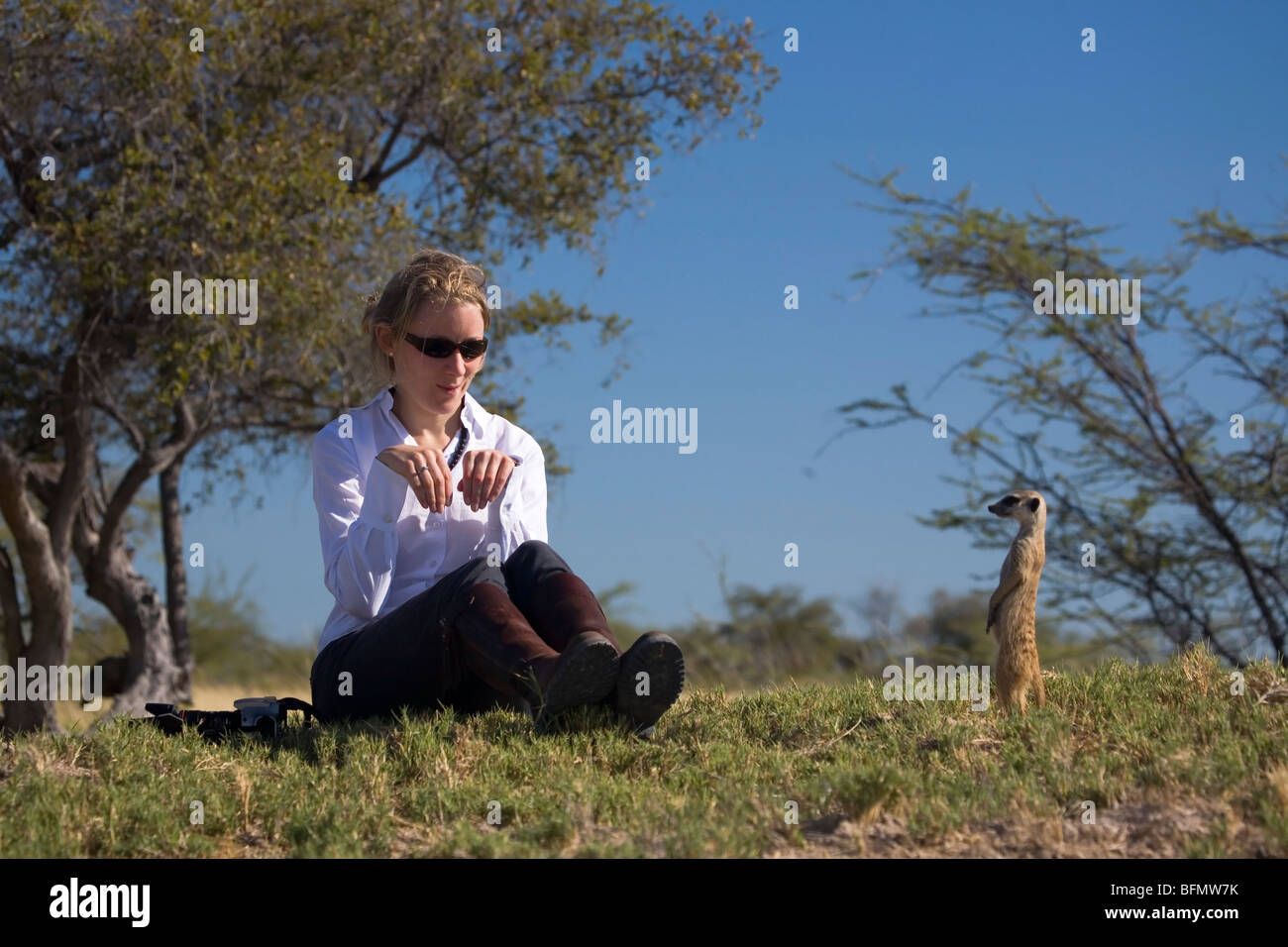 Il Botswana, Makgadikgadi. Un turista mima un meerkat. (MR) Foto Stock