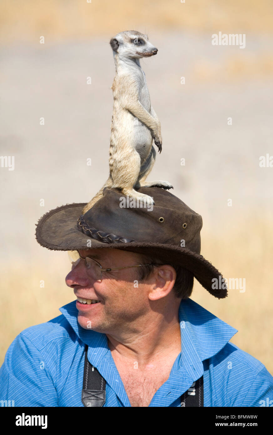 Il Botswana, Makgadikgadi. Un uomo con un meerkat hat. Foto Stock