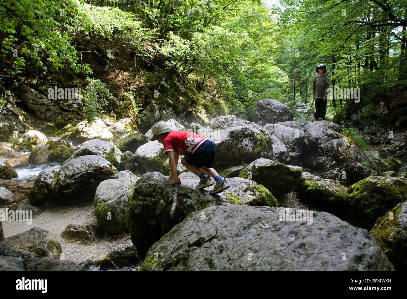 La Slovenia, il Parco Nazionale del Triglav. Due giovani ragazzi esplorare un masso-stream disseminate sull'escursione alle cascate Savica. (MR) Foto Stock