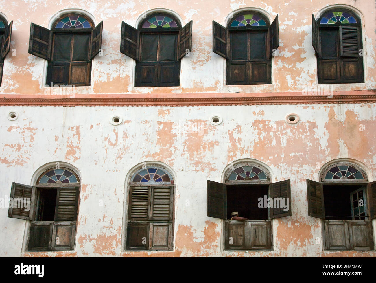 Tanzania, Zanzibar Stone Town. Le finestre con persiane di un grande vecchio edificio in pietra città. Foto Stock