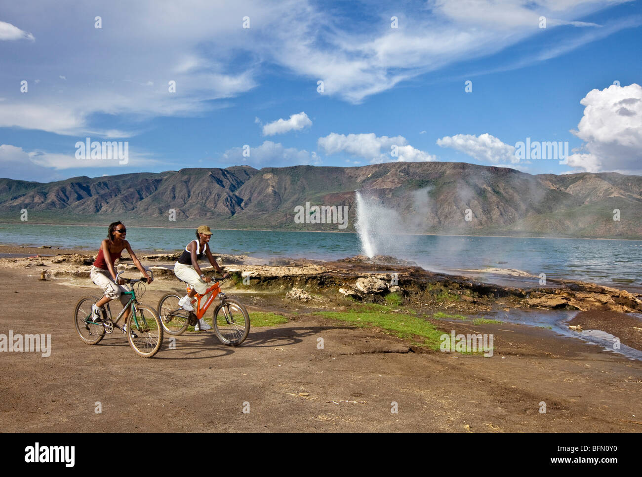 Kenya, Bogoria. Due ragazze passato del ciclo i geyser e le sorgenti di acqua calda accanto al lago Bogoria, un lago alcalino la Grande Rift Valley. Foto Stock