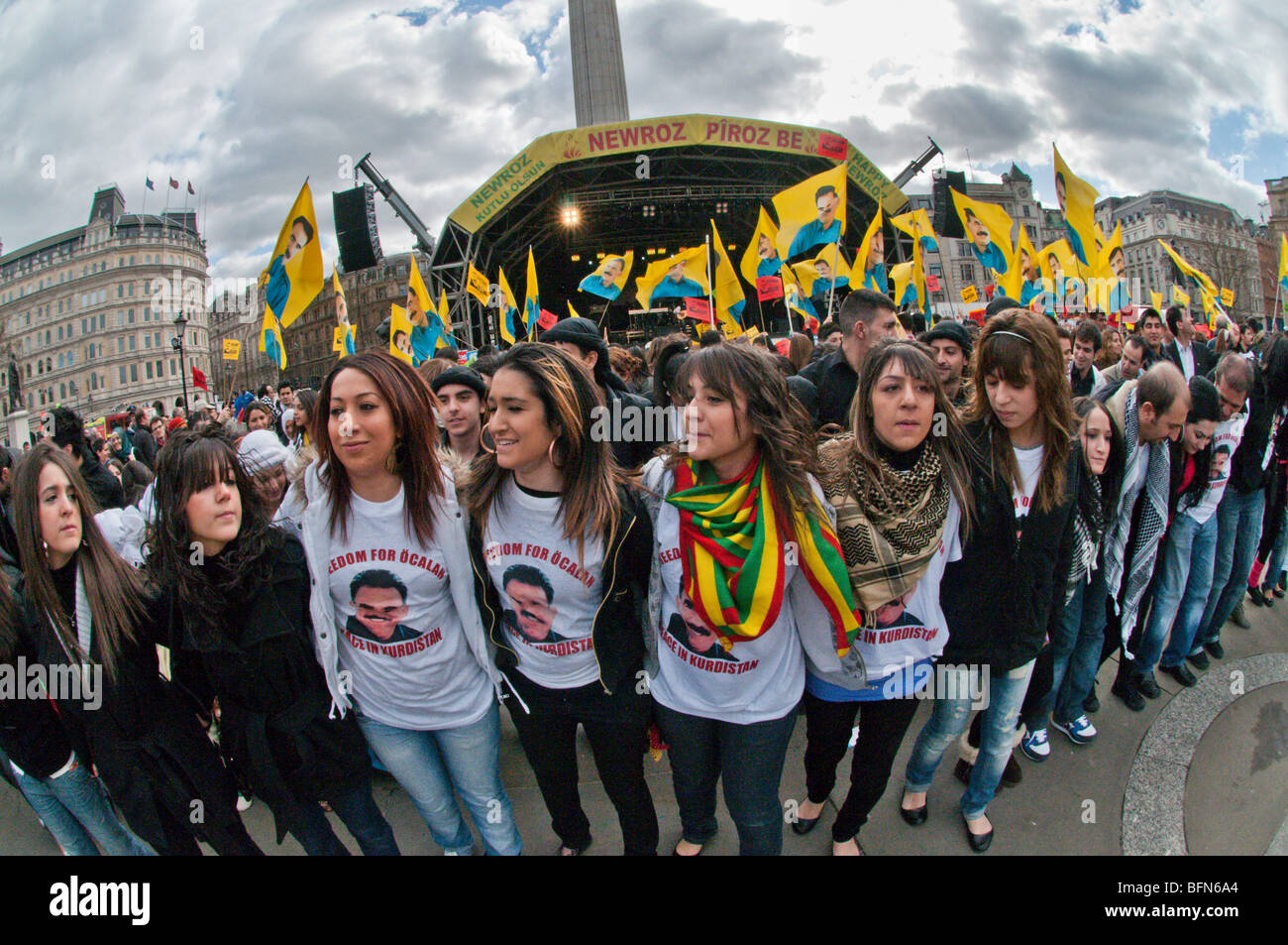 Celebrare il Newroz curdo anno nuovo - vietato in Turchia - a Londra, ballerini in libera di Ocalan t-shirts & folla con bandiere Foto Stock