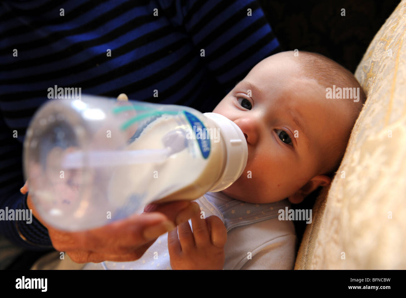 Bambino di quattro mesi boy bottiglia essendo alimentato England Regno Unito Foto Stock