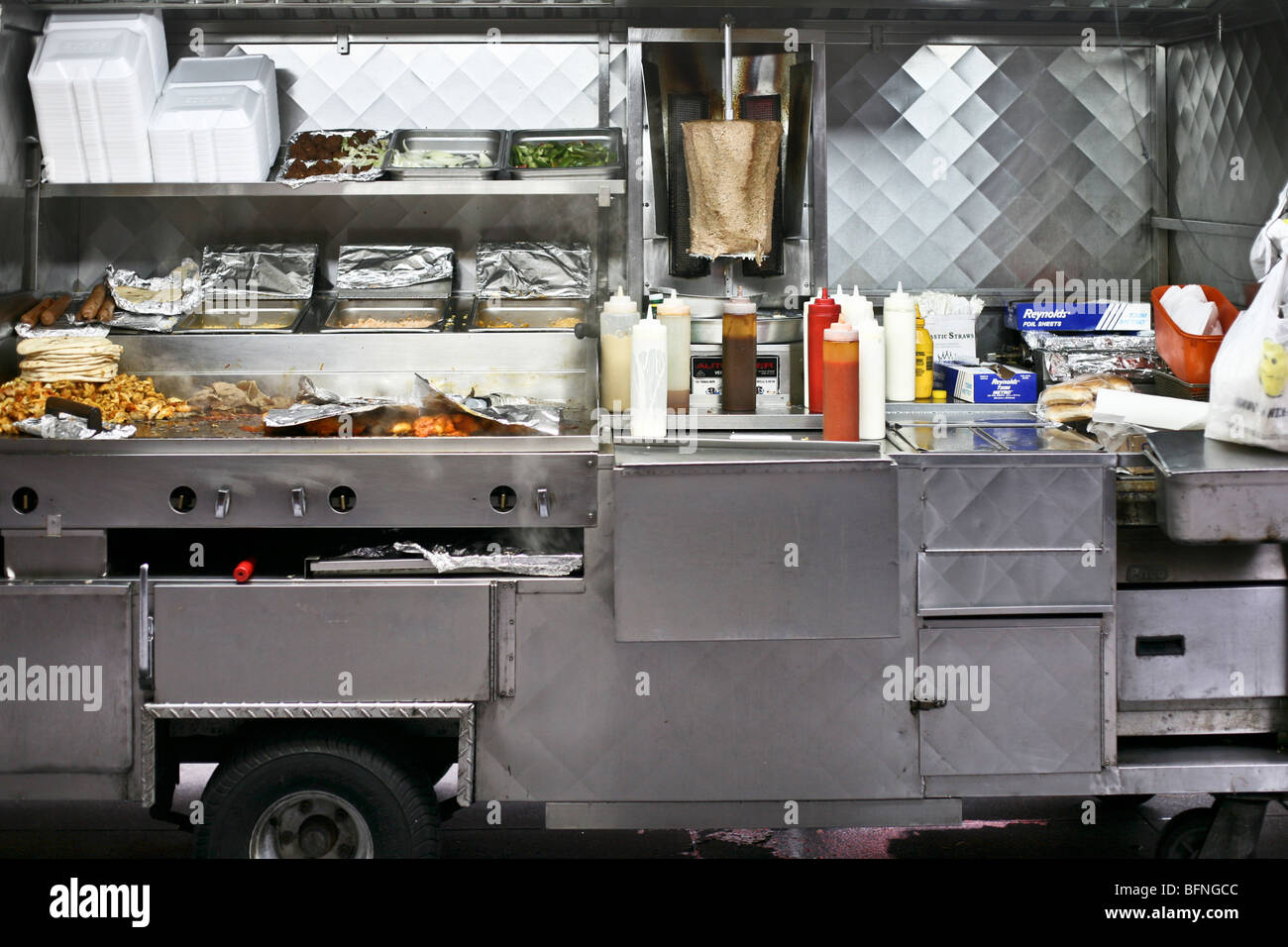 Vapore sorge allettanti contenuti di un immacolato in acciaio inossidabile aprire falafel food cart in New York City Foto Stock