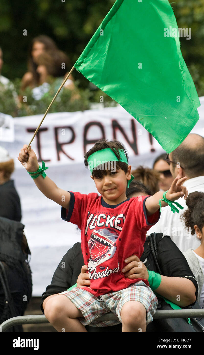 Bambino sventola una bandiera verde a protestare al di fuori dell'ambasciata iraniana, Londra Foto Stock