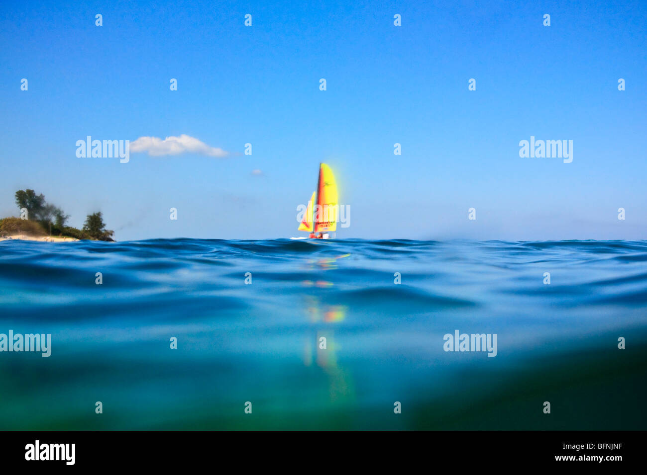 Vista di un catamarano a vela lontano all'orizzonte, mezza immersi in acqua Foto Stock