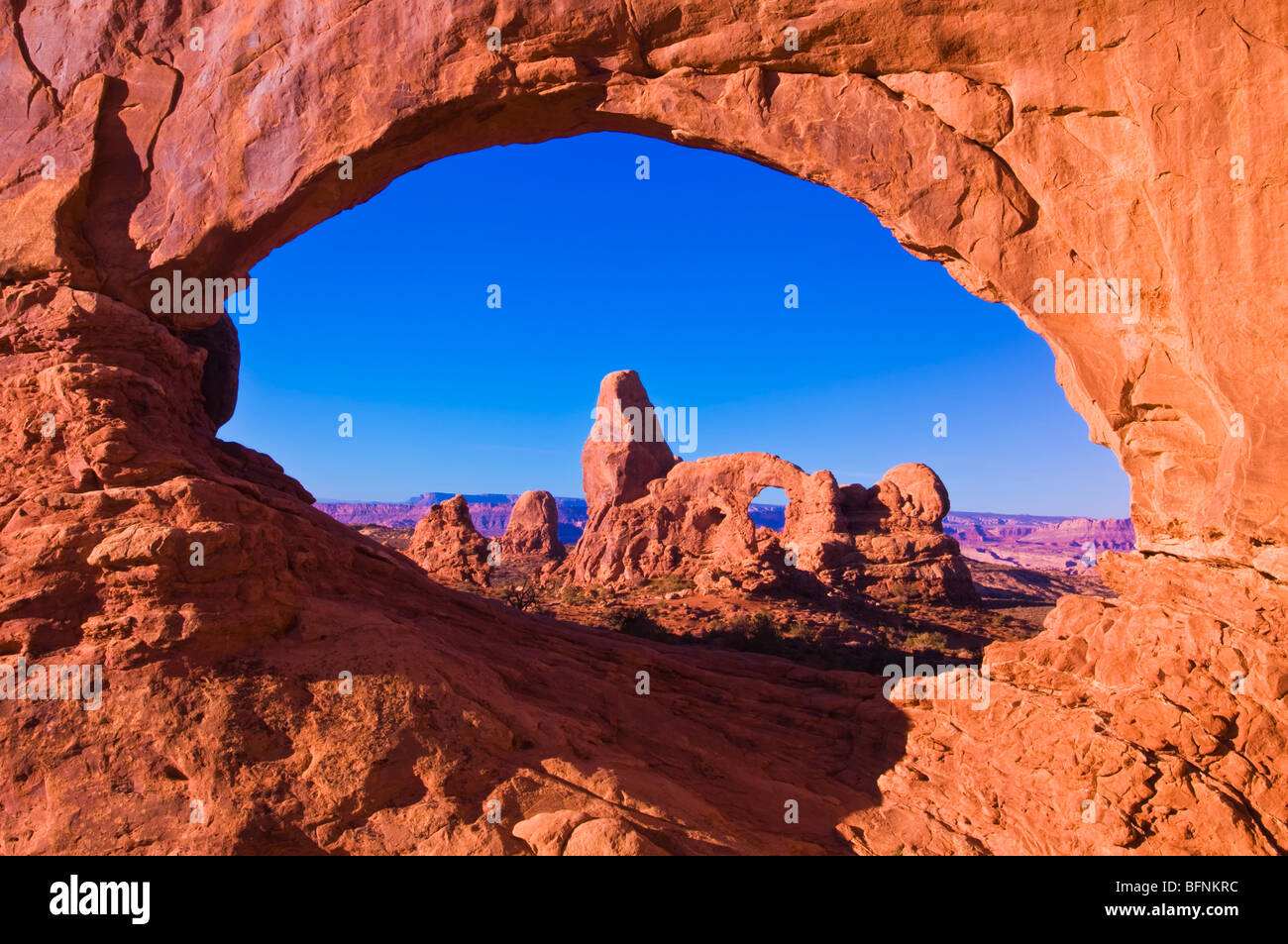 La luce del mattino sulla torretta Arch attraverso la finestra del Nord, il Parco Nazionale di Arches, Utah Foto Stock