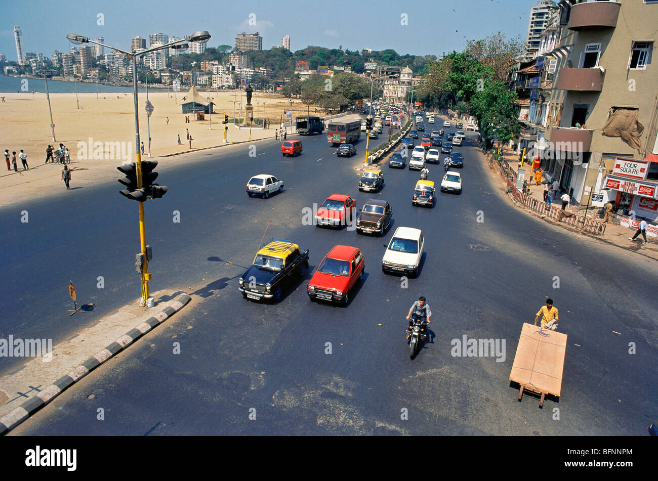 Taxi ; automobile ; bike un carrello a mano ; traffico su strada segnale di chowpatty ; Mumbai Bombay ; Maharashtra ; India Foto Stock