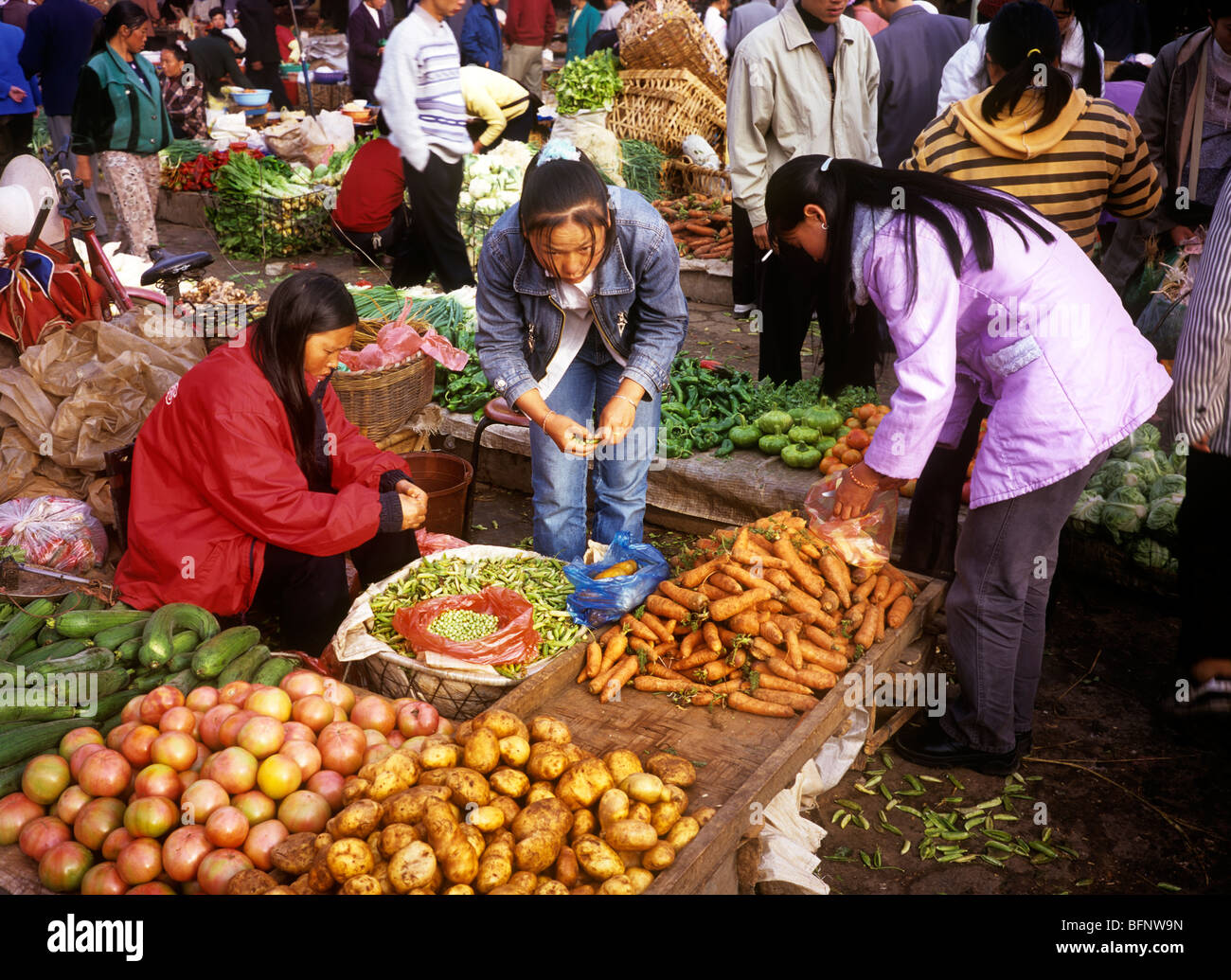 Cina Yunnan, Xishuangbanna, Menghai mercato venditore vegetali Foto Stock