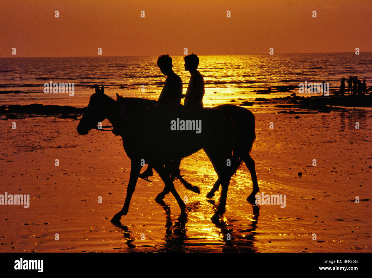 HPA 63339 : cavalieri al tramonto sulla spiaggia di Juhu cavalieri ; Mumbai Bombay ; Maharashtra ; India Foto Stock