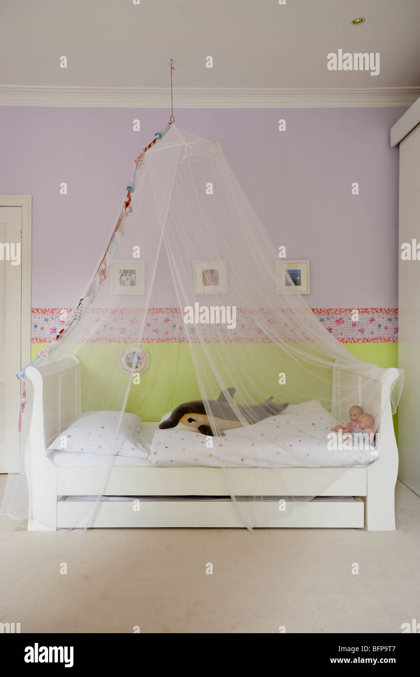 Ragazze camere da letto decorate in delicate sfumature con una farfalla confine dal designer Guild Foto Stock
