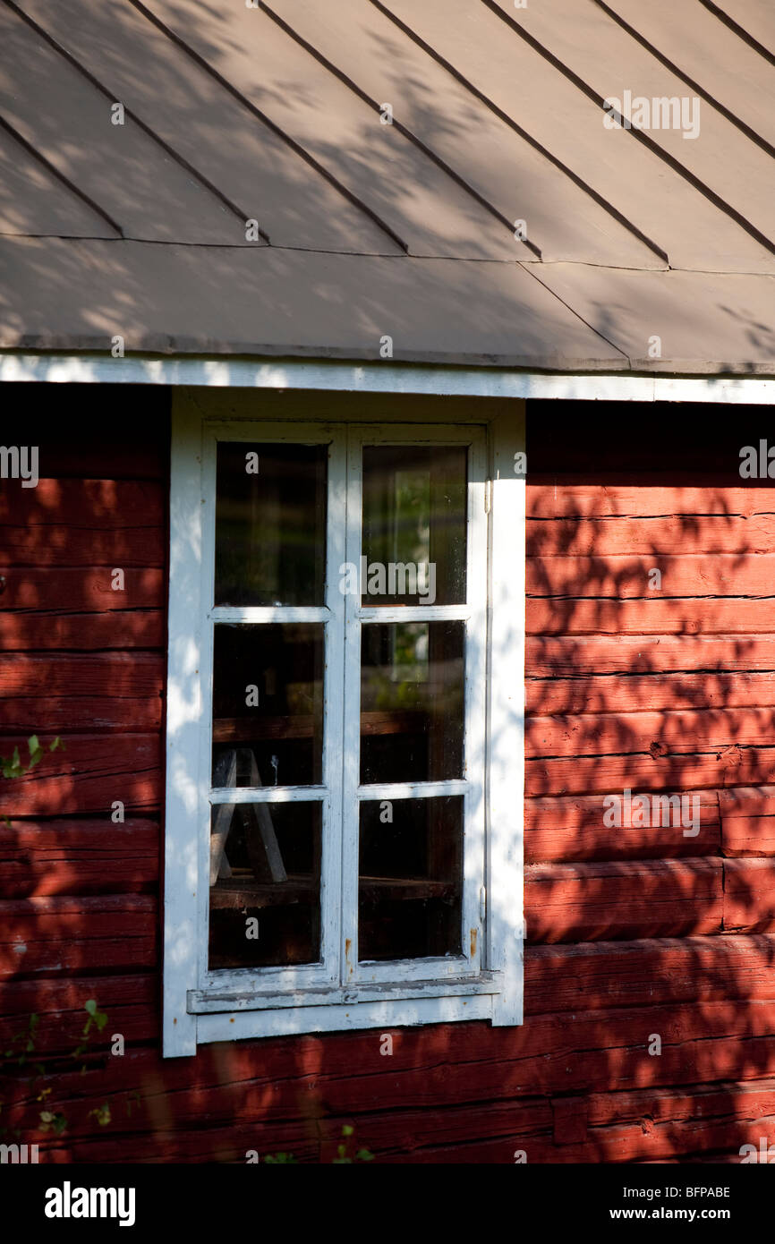 Finestra in legno verniciato ocra rosso legno cabina muro , Finlandia Foto Stock